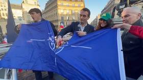 Bandera de la OTAN desfigurada como manifestación de miles en París