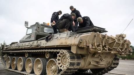 FILE PHOTO. Ukrainian recruits being taught how to maintain a Driver Tank Trainer (DTT) armored vehicle at a military facility in Southern England.