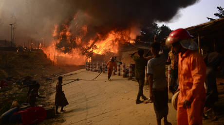 Rohingya refugees try to douse a major fire in their Balukhali camp at Ukhiya in Cox's Bazar district, Bangladesh, Sunday, March 5, 2023.