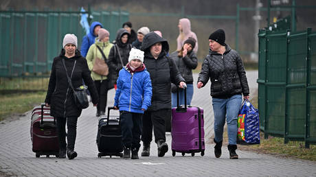 FILE PHOTO: Refugees and volunteers are seen at Medyka border crossing as people pass through in Medyka, Poland.