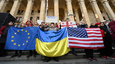 Protesters outside the Georgian parliament in Tbilisi hold up the flags of Ukraine, EU and the US, March 8, 2023.