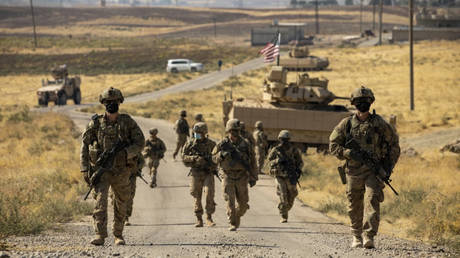 FILE PHOTO: US Army troops make their way to an oil production facility at an undisclosed location in Syria, October 27, 2020.