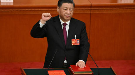 China's President Xi Jinping swears under oath after being re-elected as president for a third term at the Great Hall of the People in Beijing on March 10, 2023.
