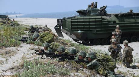 FILE PHOTO. Philippine and US marines take position next to assault amphibious vehicles (AAV) as they simulate an amphibious landing as part of the annual joint military exercise at the beach of Philippine navy's training camp in San Antonio, Zambales province northwest of Manila.