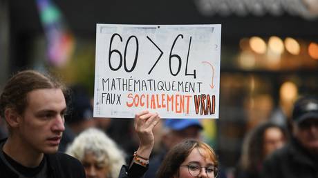 A protester holds a placard reading “60>64 mathematically false socially true” during a demonstration against proposed pension reforms on March 11, 2023, Brest, France