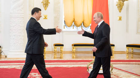 FILE PHOTO. Chinese President Xi Jinping shakes hands with Russian President Vladimir Putin ahead of their talks in Moscow, Russia.