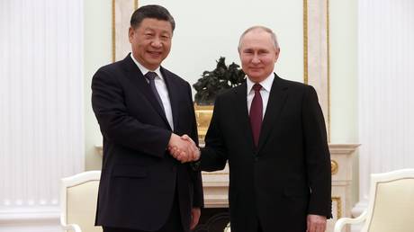 Chinese President Xi Jinping and Russian President Vladimir Putin shake hands during their meeting at the Kremlin in Moscow