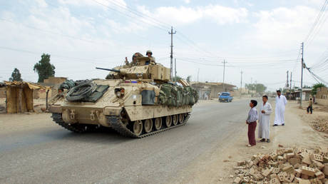 FILE PHOTO: US troops patrol the streets of Duluiyah, north of Baghdad, after the invasion of Iraq, June 13, 2003.
