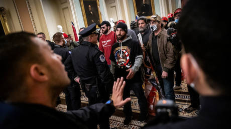 FILE PHOTO: Protestors interact with police inside the US Capitol during the January 2021 riot in Washington.