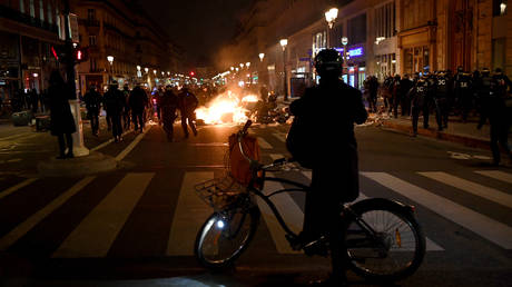 A biker overlooks a fire during a demonstration on Monday in Paris.