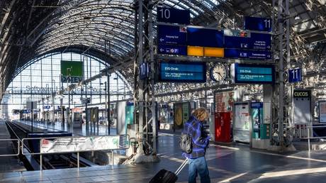 A commuter checks her mobile phone during a public transport strike at the main railway station in Frankfurt am Main, Germany, March 27, 2023