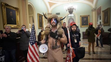 Jacob Chansley, also known as the "QAnon Shaman," stands among a group of pro-Trump protesters outside the Senate chamber of the US Capitol Building on January 6, 2021