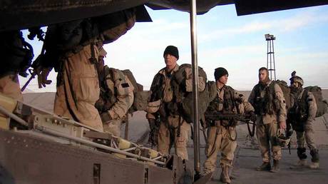 FILE PHOTO: US troops load up at Uzbekistan's Karshi-Khanabad Air Base for a February 2004 flight into Afghanistan.