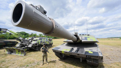 An infantryman stands next to a Panther KF51 battle tank at the Rheinmetall plant in Unterlüß, Lower Saxony, Germany, July 14, 2022.