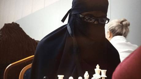 Удивленный шахматист-мужчина, выступающий за женщину