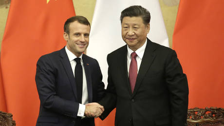 French President Emmanuel Macron shakes hands with China's President Xi Jinping