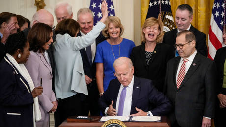 Sen. Dianne Feinstein (D-CA) raises her hand to say she didn't receive a commemorative pen as U.S. President Joe Biden looks for one after signing the VOCA Fix to Sustain the Crime Victims Fund Act of 2021 into law in the East Room of the White House on July 22, 2021 in Washington, DC.