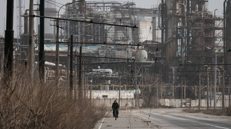 A man cycling near the Azot chemical plant. Severodonetsk, Lugansk People’s Republic, March 2023.