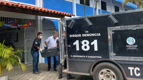 Police carry away the body of a victim at the Aracruz secondary school where a 16-year-old shot several people in November