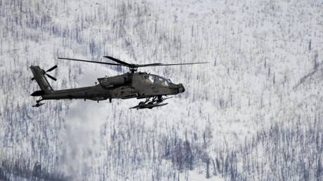 FILE PHOTO: An AH-64 Apache flies over the Yukon Training Area, adjacent to Fort Wainwright, Alaska