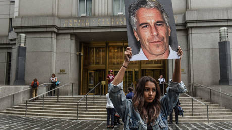 FILE PHOTO: A protestor holds up a photo of accused child-sex trafficker Jeffrey Epstein outside the federal courthouse in New York City in July 2019.