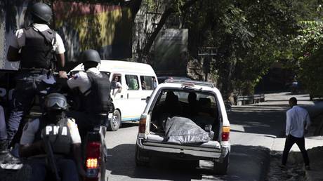 Police carry away the bodies of slain journalists in Port-au-Prince, Haiti, January 7, 2022