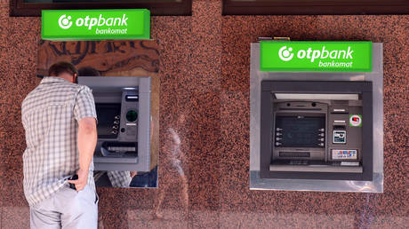 FILE PHOTO: A man withdraws money from a cash machine of Hungarian OTP Bank in Budapest, Hungary.