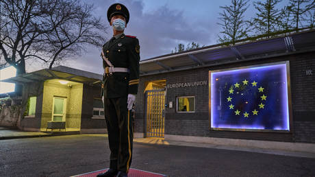 A member of the Peoples Armed Police stands guard in front of the flag of the European Union at the European Delegation before a press conference by European Commission President Ursula von der Leyen on April 6, 2023 in Beijing, China.
