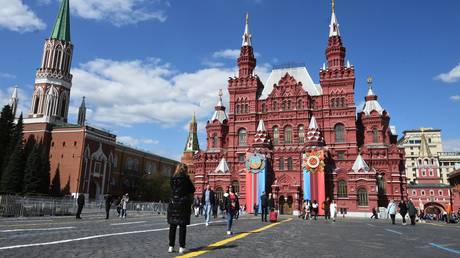 FILE PHOTO: People walk at the Red Square decorated for the upcoming Victory Day celebrations in Moscow