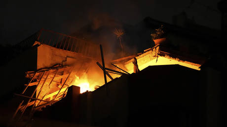 Fire burns at an apartment building following Israeli airstrikes in Gaza City on May 9, 2023