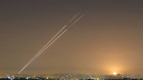 Militants launch rockets from Gaza City as an Israeli bomb explodes on the horizon on November 21, 2012 on Israel's border with the Gaza Strip