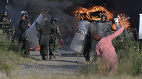 A supporter of Pakistan's former Prime Minister Imran Khan throws a stone towards police officers during clashes in Islamabad, Pakistan, May 10, 2023.