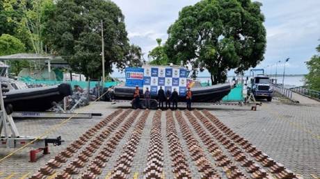 Colombian military personnel pose next to three tons of cocaine seized from a submarine in the Pacific Ocean, May 12, 2023