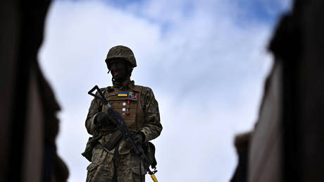 A Ukraine Army recruit stands on the edge of a trench as they take part in a warfare training session at a UK training base in southern England on March 27, 2023.