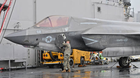 A US service member checks over an F-35 fighter jet during a press tour of the USS Makin Island on March 23 in Busan, South Korea.