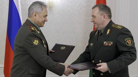 Russian Defense Minister Sergei Shoigu, left, and Belarusian Defense Minister Viktor Khrenin exchange documents during a meeting after a session of the Council of Defense Ministers of the Collective Security Treaty Organization (CSTO) in Minsk, Belarus, Thursday, May 25, 2023.