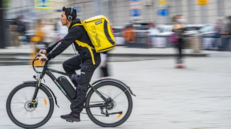 A food delivery service courier rides a bicycle, Moscow.