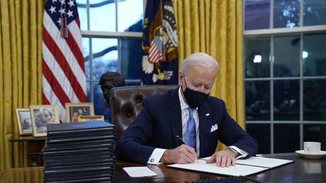 FILE PHOTO: Joe Biden signs a stack of executive orders following his inauguration at the White House in Washington DC, January 20, 2021