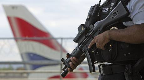 FILE PHOTO: An armed British police officer patrols outside of Heathrow Airport in London, England.