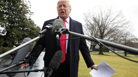 Donald Trump holds a copy of a court document as he speaks to members of the media prior to his Marine One departure from the White House February 7, 2020 in Washington, DC