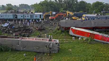 Policemen inspect the wrecked carriages of a three-train collision near Balasore, in India's eastern state of Odisha, on June 4, 2023.