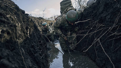 FILE PHOTO: Ukrainian soldiers shelter in a trench under Russian shelling near Artyomovsk, Russia, March 5, 2023