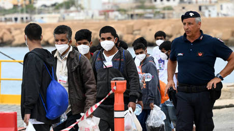 Migrants wait to board a boat at the Italian island of Lampedusa, south of Sicily, June 8, 2023.