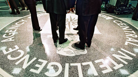 George W. Bush, Central Intelligence Agency Director George Tenet and others stand on the seal of the Agency March 20, 2001 at the CIA Headquarters in Langley, Virginia