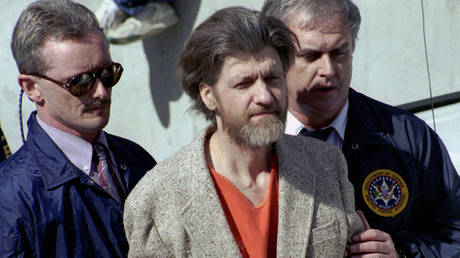 FILE PHOTO: Theodore 'Ted' Kaczynski is flanked by federal agents as he is led to a car from the federal courthouse in Helena, Montana, April 4, 1996