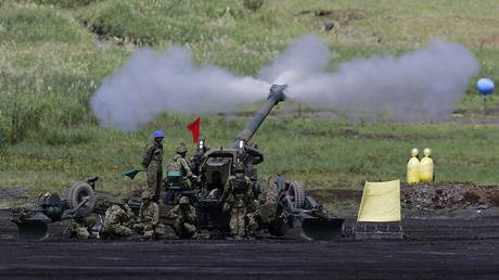 FILE PHOTO: Japan Ground Self-Defence Force soldiers fire a 155mm howitzer during the rehearsal for annual live firing exercise at the JGSDF's East Fuji Maneuver Area in Gotemba, Japan.