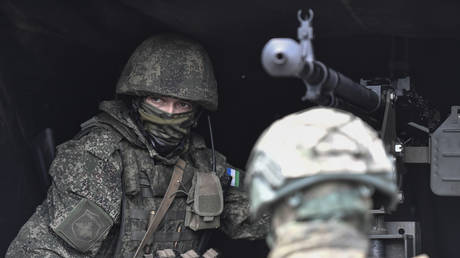 A Russian servicemen of a mobile anti-aircraft unit sits by a DShK machine gun loaded on a UAZ truck as he is on combat duty for repelling attacks of Ukrainian unmanned aerial vehicles.