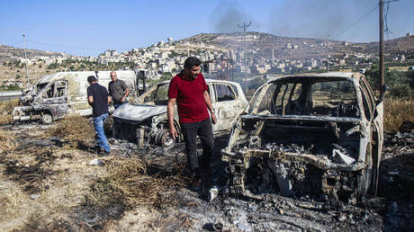 Palestinians inspect burnt cars that were set on fire by Jewish settlers during an attack on the town of Al-Laban al-Sharkiyeh, in the northern West Bank.