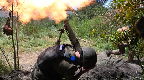 Ukrainian troops fire a mortar towards Russian positions.