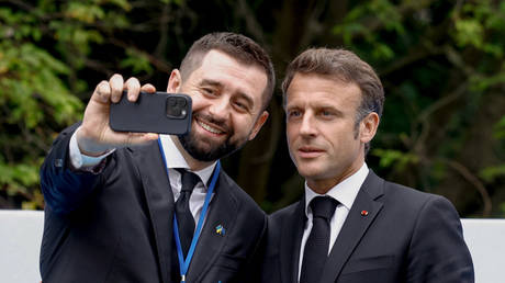 David Arakhamia (L) takes a selfie photograph with France’s President Emmanuel Macron (R), in Brussels, on June 29, 2023.